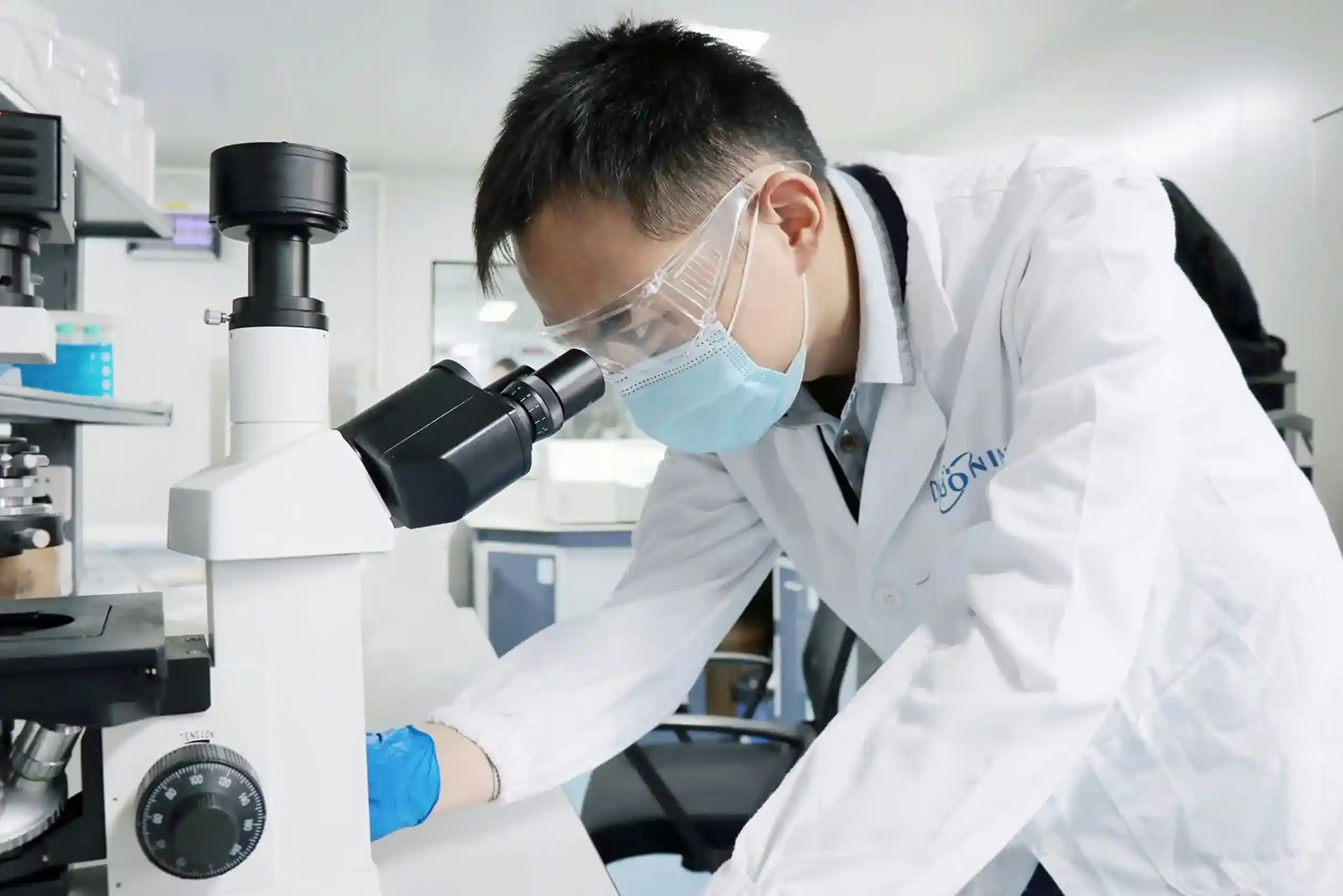 An image of a researcher peering into a microscope